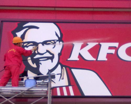 清洗人員在清洗紅色的廣告牌